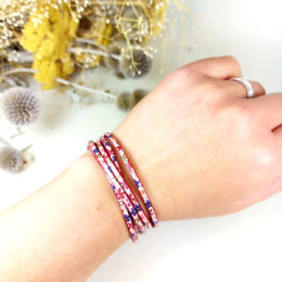 bracelet fin en cuir enroulé plusieurs fois et porté au poignet